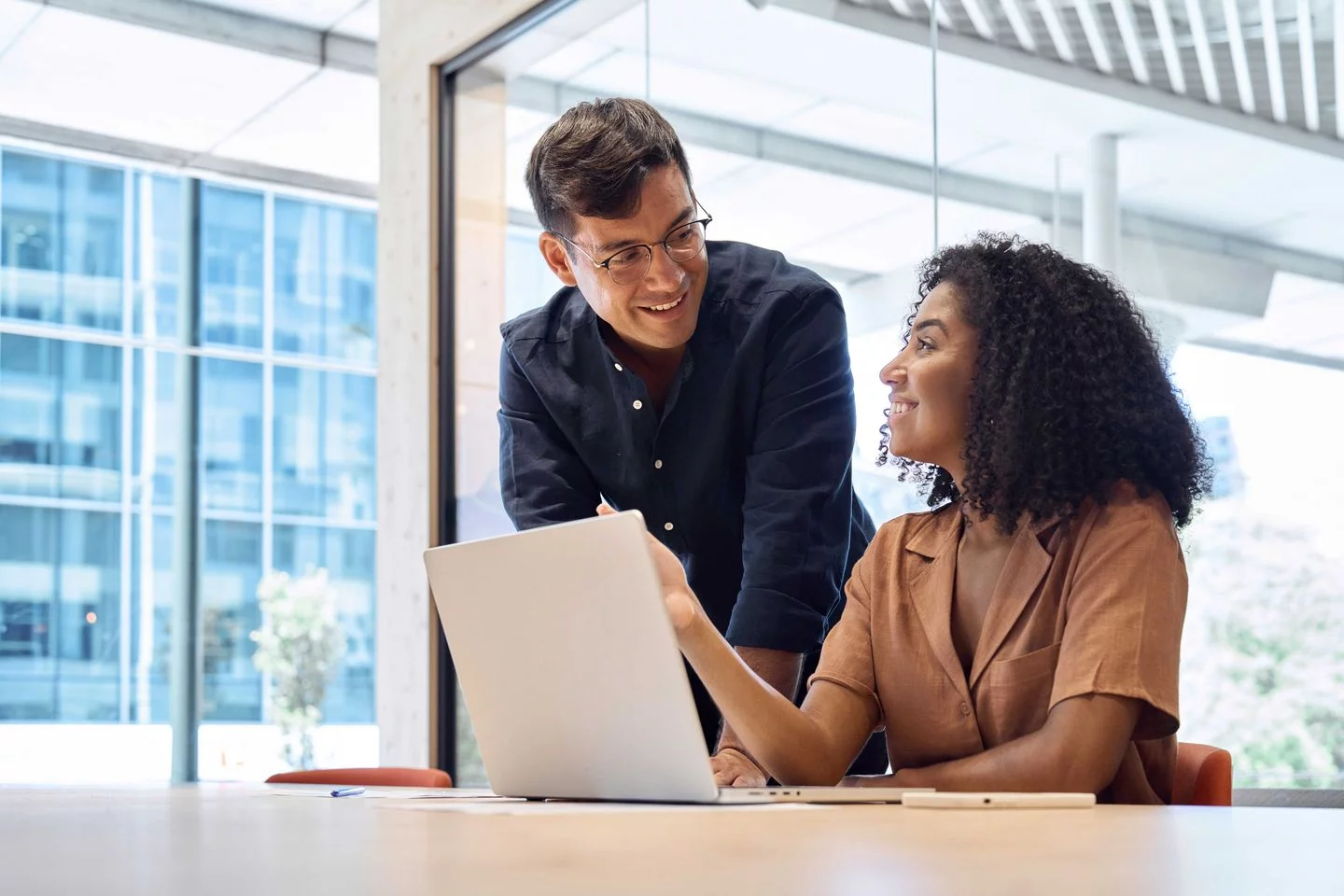 man and woman working together at desk